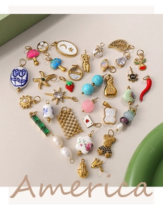 Collection de pendentifs DIY dorés disposés en forme de cœur sur un tissu gris neutre