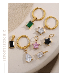 Vue macro de breloques dorées DIY avec zircons colorés sur une surface en pierre