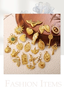 Detailed view of vintage 18K gold plated charms including heart, sun and key motifs