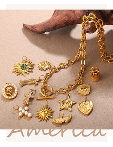 Macro shot of vintage 18K gold plated charms with heart, sun, and pearl details