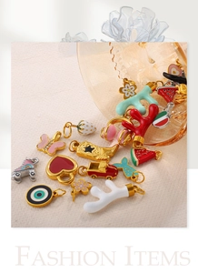 Macro view of 18K gold-plated charms with colorful enamel details on textured fabric