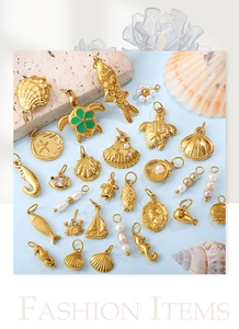 Flat lay of gold ocean themed charms with pearls and enamel on a beach style background