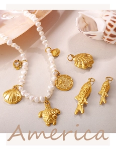 Detail of freshwater pearl necklace with gold ocean charms including fish and sea turtle