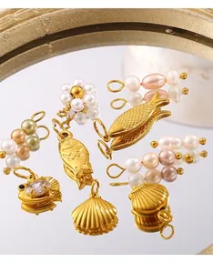Detailed macro shot of golden ocean theme fish and shell pendants with white pearls