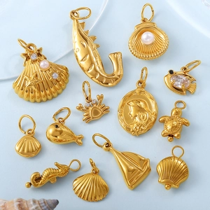 Golden ocean theme charms set with shells, seahorse and pearls on light blue background