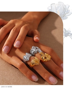 Detailed close-up of chunky molten lava rings in gold and silver on a hand