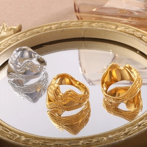 Irregular liquid metal rings in gold and silver finish with wavy lava texture