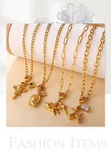 Detail of 18K gold plated charms including elephant and balloon dog on Figaro chains
