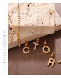 Detailed close-up of 18K gold plated letter pendants with micro-pave cubic zirconia
