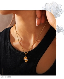Close-up of 18K gold plated bear pendant necklace with pearls on a model
