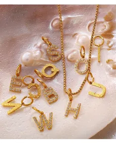 Detail of 18K gold plated alphabet pendants with pavé zircon and hammered texture finish