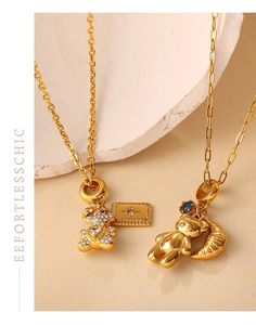 Detail of 18K gold-plated bear pendants with white crystals, blue sapphire, and moon charm