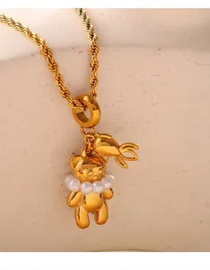 Detail of 18K gold plated bear pendant with pearl collar and carrot charm on rope chain