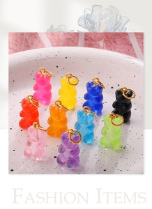 Macro shot of 10 colorful gummy bear resin pendants with gold metal rings for jewelry DIY