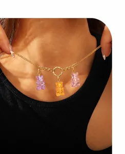 Close-up of a necklace with three colorful translucent resin bear pendants on a gold chain