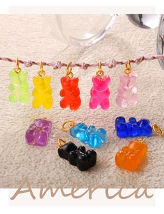Detailed close-up of ten colorful resin bear pendants with gold rings for DIY jewelry