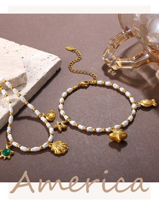 Macro detail of ocean-themed stainless steel bracelet with shell and turtle charms