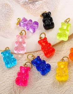 Macro shot of colorful translucent resin bear pendants on white textured stone surface