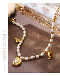 Detail of 18K gold ocean bracelet with freshwater pearls, shell and fish charms