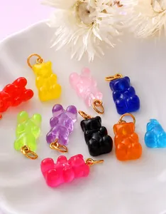 Close-up of colorful resin gummy bear charms on white ceramic plate for DIY jewelry making