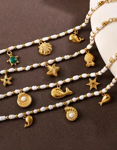 Detailed macro view of 18K gold ocean charms with baroque pearls on a textured background