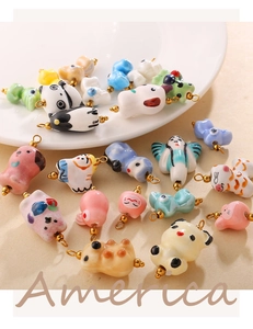 Macro shot of colorful handmade ceramic animal charms with glossy glaze and golden rings