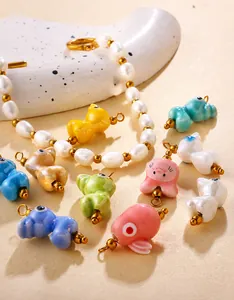 Macro detail of handmade ceramic animal charms and freshwater pearl DIY jewelry set