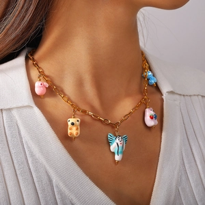 Gold chain necklace featuring five colorful hand-painted ceramic animal charms on a model