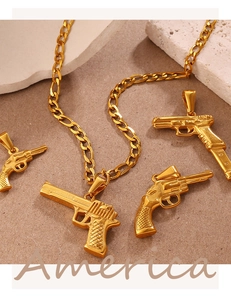 Dettaglio macro di ciondoli a pistola hip hop dorati su catene cubane e pietre bianche