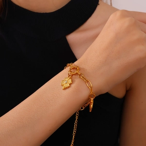 Chic gold-tone bracelet featuring a clover pendant with crystal and OT toggle clasp