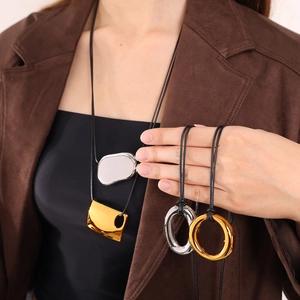 Collar con colgante geométrico minimalista en cordón negro con ropa de invierno