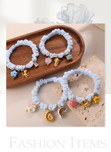 Light blue scrunchie set featuring gold marine charms like octopus and seahorse on stone