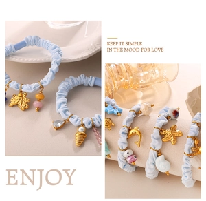 Detail of light blue scrunchies with gold sea life charms like octopus and starfish