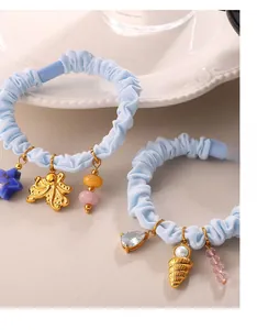 Detail of light blue scrunchies with golden sea-themed charms like octopus and shell