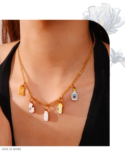 Gouden ketting gedragen door model met kleurrijke emaille bedeltjes van blikjes en harten