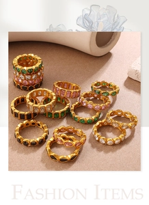 Detail view of gold-plated rings with colorful heart and teardrop gemstone settings