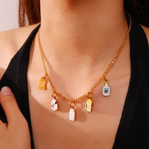 Leuke gouden ketting met kleurrijke drankbedeltjes zoals honing en melk op zwart topje