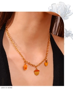 Détail d'un collier en chaîne dorée avec pendentifs en émail coloré sur un mannequin