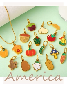 Détail de charms de légumes en émail coloré et d'un collier chaîne serpent dorée
