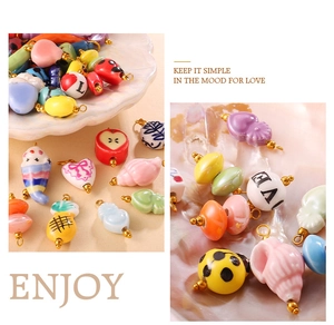 Close-up of colorful ceramic charms including hearts and ladybugs with gold metal rings