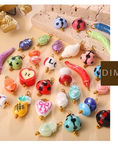 Macro shot of colorful ceramic charms including ladybug and chili for DIY jewelry making