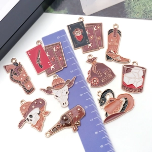 Western cowboy style enamel charms including skull and boots with ruler for scale