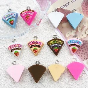 Flat lay of colorful resin strawberry cake charms with metal loops for DIY jewelry