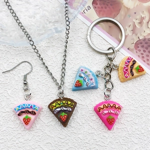 Close-up of DIY resin strawberry cake jewelry set including earrings and keychains