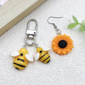 Vue détaillée du pendentif tournesol et des breloques abeille pour la création de bijoux