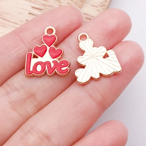 Detailansicht der roten Emaille-Herzanhänger mit Love-Schriftzug für DIY-Schmuckherstellung