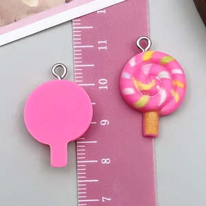 Détail macro du pendentif sucette rose de 3cm montrant la spirale et le dos plat en résine