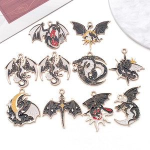 Detailed set of ten dragon-themed enamel charms in gold, black and white for DIY jewelry