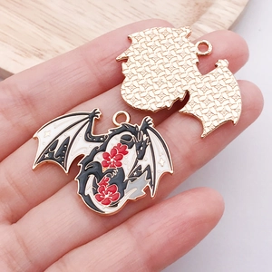 Detail of dragon pendant with black red white enamel and floral accents for DIY jewelry