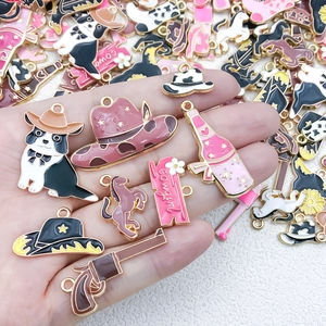 Vue détaillée de breloques de cowboy en émail coloré dans la main pour bijoux DIY